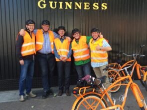 people standing at guiness in orange high vis jackets with helmets on